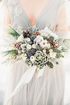 a bridal holding a bouquet of flowers and pine cones