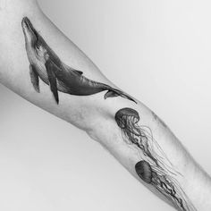 a black and white photo of a person's arm with a tattoo on it