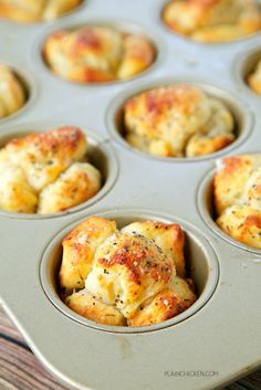 a muffin tin filled with baked goods on top of a wooden table