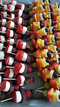 several skewers filled with fruit and veggies on sticks