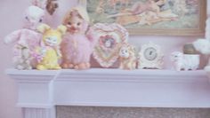 there are many stuffed animals on the mantel in this room, including one baby doll