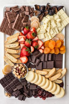 a platter filled with chocolate, fruit and crackers on top of each other