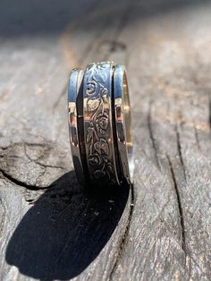 925 Sterling silver spinner ring decorated with one filigree floral texture spinning band. Details: ♦ Returns accepted ♦ Materials: Sterling silver 925 ♦ Ring Width: 0.31 inches // 8 mm ♦ All of my designs are handmade. ♦ Arrives in an elegant gift package. ♦ Not sure what size you need? Check this link: http://findmyringsize.com/ SPECIAL GIFT on every purchase! Sterling Silver Magen David Pendant BACK TO MY SHOP: www.etsy.com/il-en/shop/KingDavidJewelryIL My Shop POLICIES: RETURNS: For returns, Silver Sterling Silver Ring With Rotating Bezel, Carved Silver Filigree Ring, Traditional Silver Flower Ring For Anniversary, Silver Engraved Filigree Ring For Promise, Silver Engraved Filigree Promise Ring, Spiritual Silver Engraved Ring For Wedding, Spiritual Silver Engraved Wedding Ring, Ornate Silver Rings With Etched Details, Wide Wedding Rings