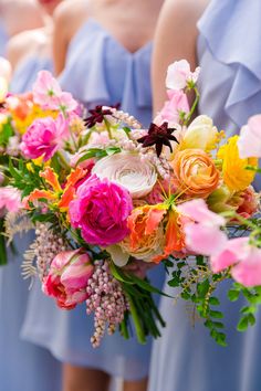 bridesmaids in blue dresses holding bouquets of flowers