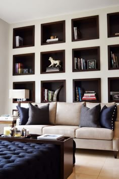 a living room filled with lots of bookshelves next to a couch and coffee table