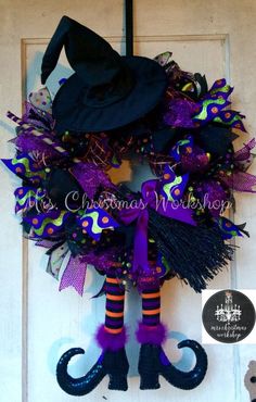 a purple and black halloween wreath with a witch's hat hanging on the front door