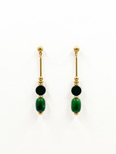 These earrings are a refined blend of natural stone and metal, ideal for someone who appreciates minimalist jewelry. The linear design incorporates distinct contrasting shapes creating a sleek and modern aesthetic.  Each earring features a geometric design with a combination of brass, matte onyx, and polished green chalcedony semi precious stones. The smooth, warm golden tone of the brass contrasts with the subtle texture of the matte black onyx coin shaped stone.  Barrel shaped chalcedony stone Minimalist Natural Stone Earrings, Green Minimalist Brass Earrings, Minimalist Green Brass Earrings, Set Theory, Chalcedony Earrings, Chalcedony Stone, Linear Design, Green Chalcedony, Gold Dangle Earrings