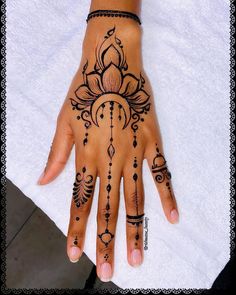 a woman's hand with henna tattoos on it