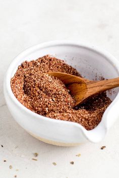 a white bowl filled with spices and a wooden spoon