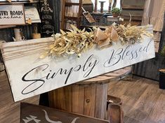 a wooden sign that says simply blessed with flowers on it in front of other signs