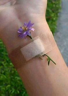 a person's wrist with a flower wrapped around it and tape on the wrist