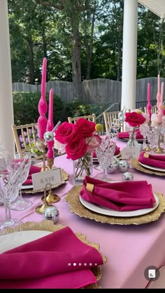 the table is set with pink napkins and place settings