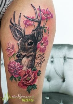 a woman's thigh with a deer and flowers on it