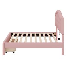 a pink bed frame with wooden slats