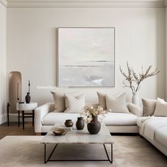 a living room filled with furniture and a painting on the wall above it's coffee table