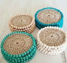 four round woven coasters with blue and white beads on the top, sitting on a wooden floor