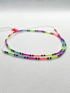 Here is the colorful glassbead necklace 💜💛💚 with neon Miyuki beads. Boho & hippie style 💙❤️ We designed this neon minimal necklace, using with Miyuki Delica 11/0 beads. We strung each bead on strong thread (0.8 mm width) one by one.  With the sliding knot you can easily adjust the Lenght of necklace.  Necklace length :  Part with Beads Lenght : 33 cm  (13 inch) Total Lenght of necklace : 66 cm (26 inch) ✨❤️💙 This colorful necklace will add color to your style in your daily combinations and Trendy Necklace With Spacer Beads For Summer, Casual Festival Jewelry With Tiny Beads, Handmade Minimalist Beaded Bracelets For Festivals, Multicolor Tiny Beads Necklace For Friendship, Minimalist Handmade Beaded Bracelets For Festival, Adjustable Rainbow Beaded Necklaces For Summer, Adjustable Beaded Necklace With Letter Beads For Festival, Rainbow Beaded Necklaces For Summer Festivals, Handmade Minimalist Friendship Bracelets For Festivals