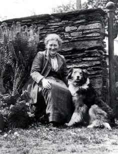 an old black and white photo of a woman with two dogs