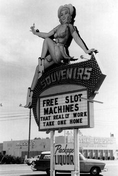 an old photo of a woman sitting on top of a sign that reads, free slot machines material by work take one home