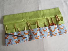 a pair of scissors and some knitting needles in a bag with foxes on the side