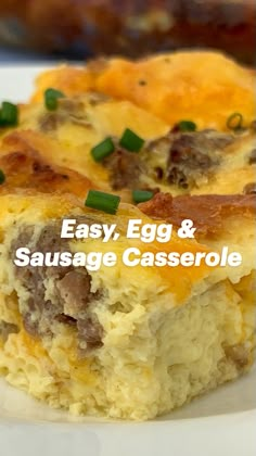 a piece of breakfast casserole on a white plate with green onions and sausage