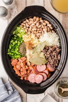 the ingredients in this slow cooker include beans, meats, and vegetables to make an entree