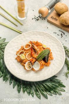 a white plate topped with pasta and clams