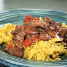 a blue plate topped with pasta and beef