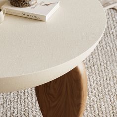 a coffee table with a book and vase on top