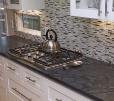 a tea kettle sitting on top of a stove in a kitchen