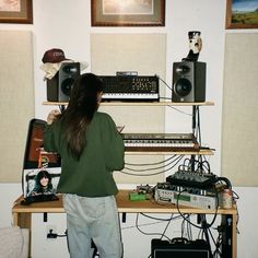 a woman standing in front of a computer desk with sound equipment on top of it