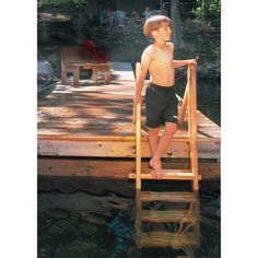 a young boy standing on a wooden dock