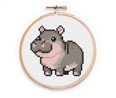 a cross stitch hippo is shown in the hoop