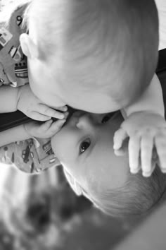 a baby is holding his head up to the camera