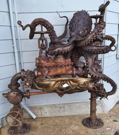 an octopus sculpture sitting on top of a wooden table next to a building with white siding