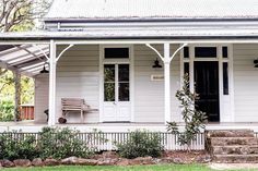 a white house with an awning and steps leading up to the front door area