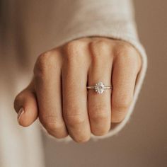 a woman's hand with a diamond ring on her finger, showing the middle finger