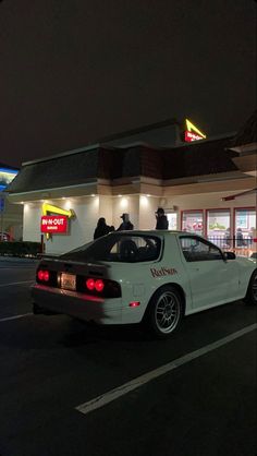 a police car is parked in front of a fast food restaurant at night with the lights on