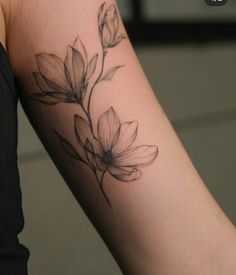 a woman's arm with a flower tattoo on the left side of her arm