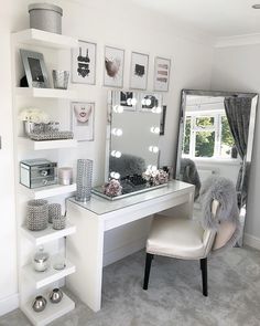 a white desk with a mirror and some pictures on the wall