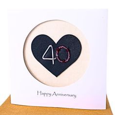 an anniversary card with the number forty on it's heart and beaded bracelet