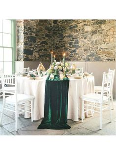 the table is set with white and green linens