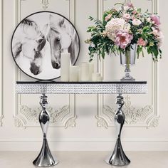 two vases filled with flowers sitting on top of a table next to a mirror