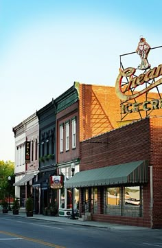 an old fashioned storefront on the corner of a street in front of some brick buildings