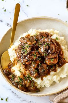 a bowl filled with mashed potatoes covered in mushroom gravy