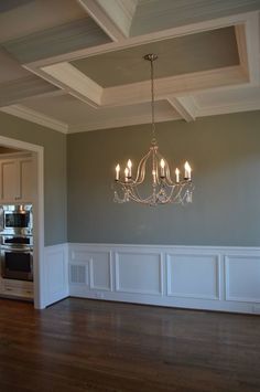 a chandelier hanging from the ceiling in a room with hard wood flooring