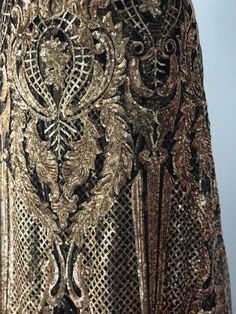 Stunning piece of embroidery, thousands of orangy gold sequins embroidered on black tulle to form this intricate design. This fabric is suitable for a stunning outfit to impress. Width is 140cm. Price is for one meter. Orders over one meter will be a continuous length of fabric. Elegant Intricate Embroidery Fabric For Evening, Glamorous Festive Embroidered Fabric, Black Embellished Sequin Fabric, Glamorous Style, Black Embellished Sequin Fabric For Formal Occasions, Elegant Embroidered Fabric For Evening, Elegant Embroidered Fitted Fabric For Evening, Elegant Embroidered Fabric With Sequins For Formal Use, Elegant Embroidered Fabric With Sequins For Formal Occasions, Elegant Sequined Embroidered Fabric For Formal Occasions