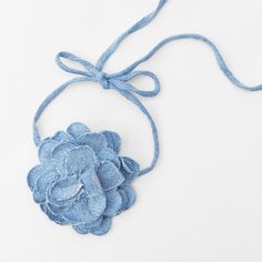 a blue flower is hanging from a string