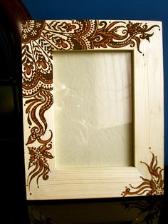 a wooden frame sitting on top of a table next to a vase and blue wall