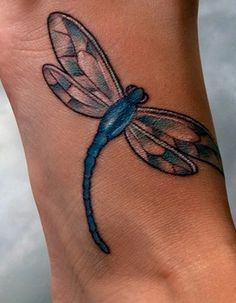 a blue dragonfly tattoo on the wrist